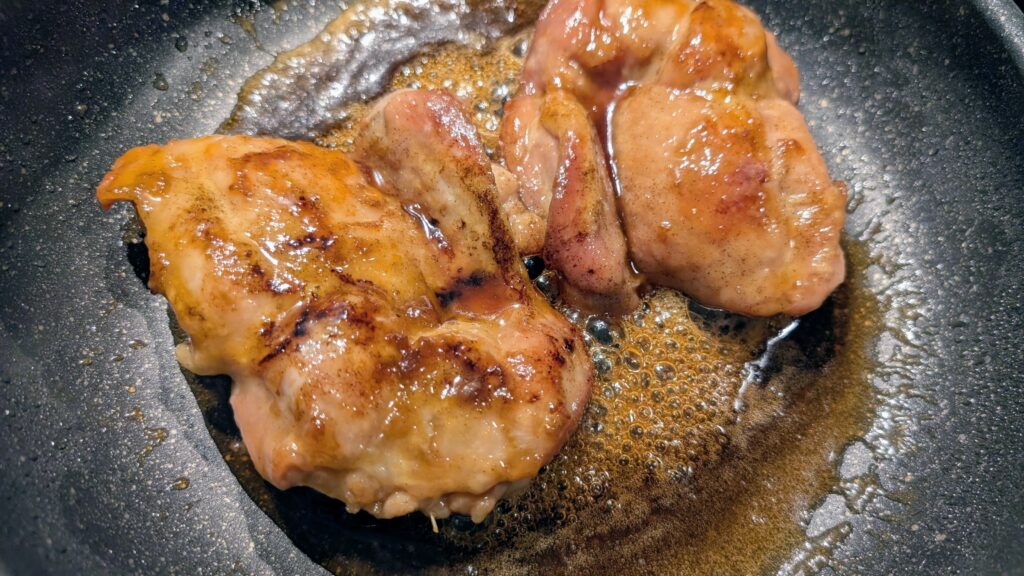 Halal chicken teriyaki glazing in the pan with no-mirin teriyaki sauce, golden and sticky
Caption: The sauce starts to bubble and thicken — this is the moment everything comes together.