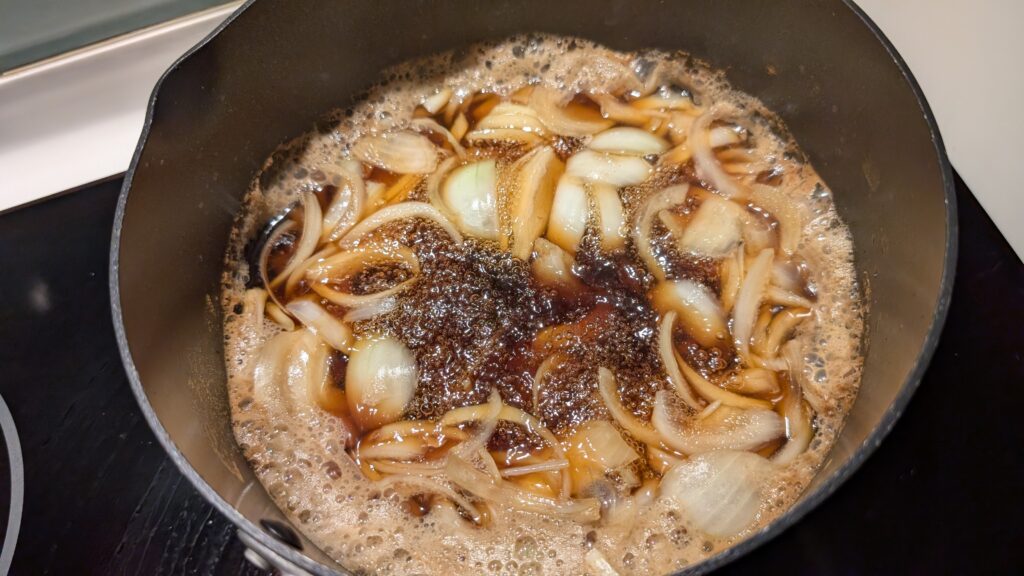 onions simmering in dashi broth for halal oyakodon recipe