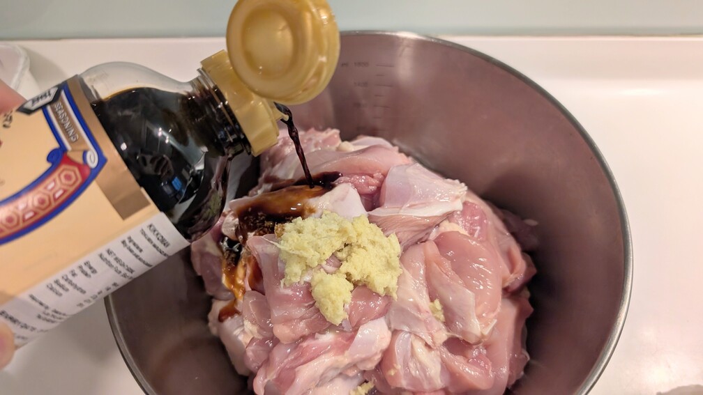 Soy sauce and grated ginger and lemon juice added to chicken for halal chicken karaage marinade