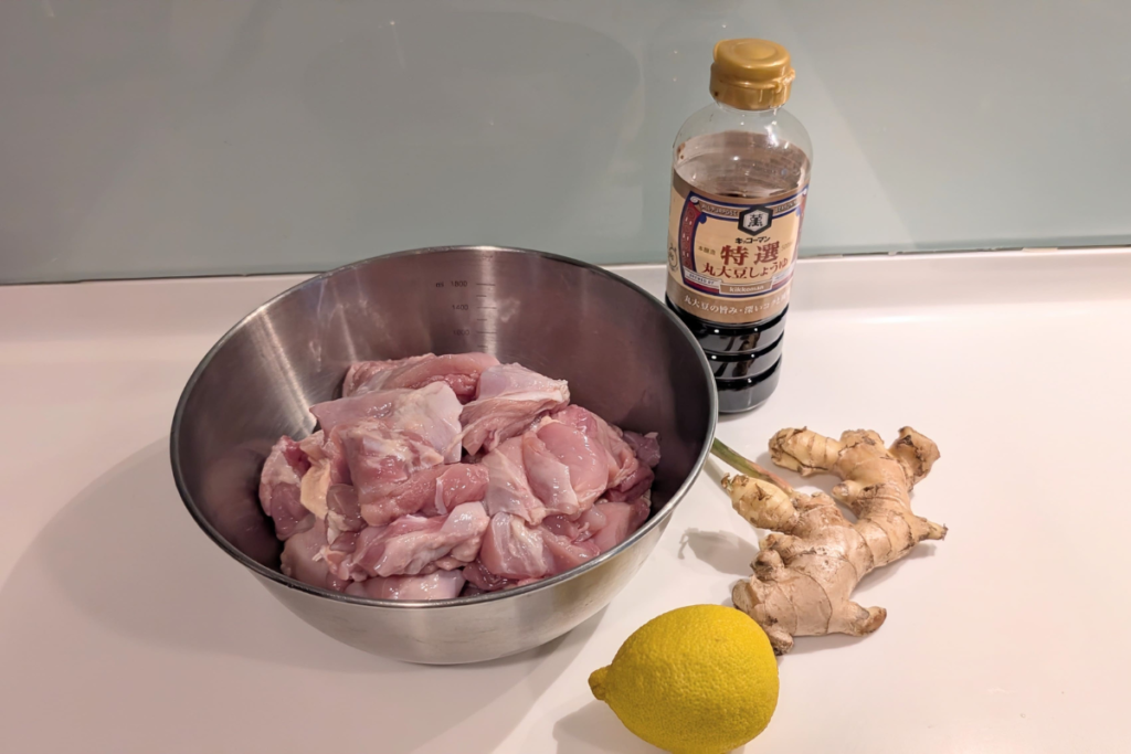 Ingredients for halal chicken karaage including chicken thighs soy sauce ginger and lemon